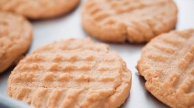 Adım adım. Taze pişmiş fıstık ezmeli kurabiyeleri tuzla süslüyor..