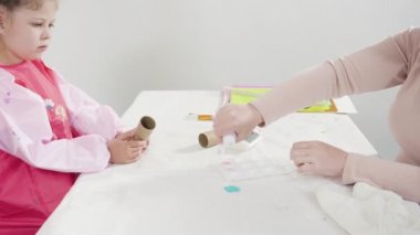 Küçük kız evde eğitim projesi için akrilik boyayla heykelcikler boyuyor..