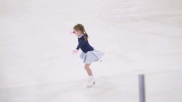 Kleines Mädchen Übt Eiskunstlauf Elemente Einem Rosa Kleid Mit Strass — Stockvideo