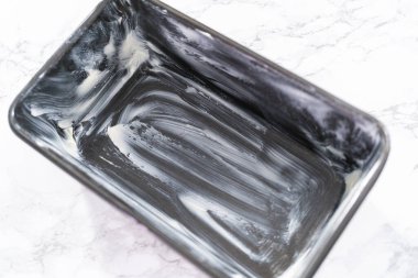 Muz ekmeği pişirmek için tereyağlı tavayla yağlanmış..