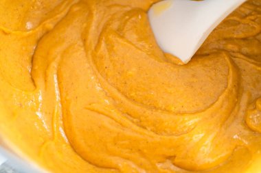 Plastik spatulayla karıştırılmış kabaklı baharatlı kek hamuru..