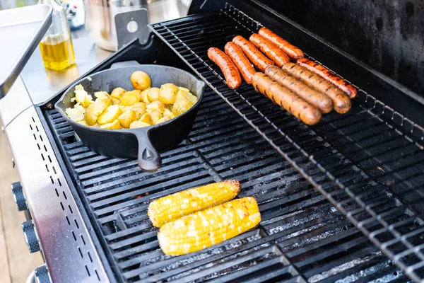 夏の屋外ガスグリルでホットドッグと新鮮な野菜を焼く — ストック写真