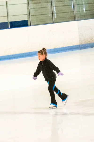 Siyah Elbiseli Küçük Artistik Patinajcı Kapalı Buz Arenasında Pratik Yapıyor — Stok fotoğraf