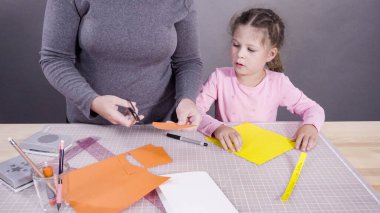 İnşaat kağıdından el yapımı Babalar Günü kartı yapan küçük bir kız..