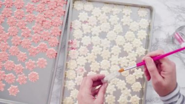 Beyaz İtalyan tereyağlı uzun yuvarlak bir pasta süslemek ve şekerli kar taneleriyle süslemek..