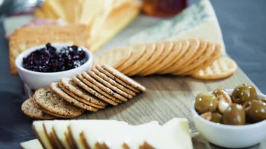 Büyük bir peynir tahtası için tahtanın üzerinde gurme peynir, kraker ve meyve düzenlemek.