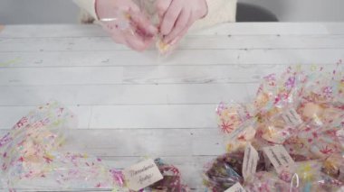 Adım adım. Ev yapımı şekerleme paketleri küçük hediye paketlerine konuyor..