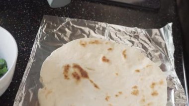 Zaman aşımı. Un tortilla içinde taze sebze, yumurta ve pastırma ile kahvaltıda burrito pişirmek..