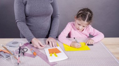 İnşaat kağıdından el yapımı Babalar Günü kartı yapan küçük bir kız..