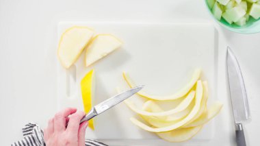 Adım adım. Düz yatıyordu. Beyaz kesme tahtasında kaygan altın çiğ taneli kavun.