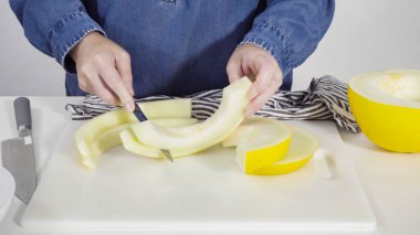 Adım adım. Beyaz kesme tahtasında kaygan altın çiğ taneli kavun.