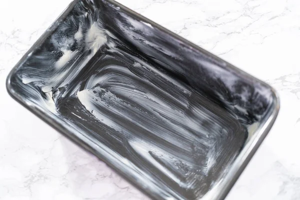 Muz ekmeği pişirmek için tereyağlı tavayla yağlanmış..