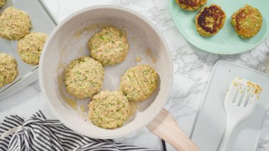 Düz yatıyordu. Adım adım. Küçük bir tavada zeytinyağında kabak keki kızartıyorum..