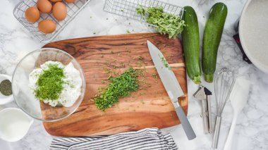 Düz yatıyordu. Adım adım. Taze otlarla ekşi kremayı karıştırıyorum..