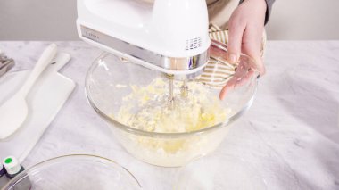 Adım adım. Vanilyalı Mardi Gras kekleri pişirmek için karışımı elektrikli mikserle karıştırıyorum..