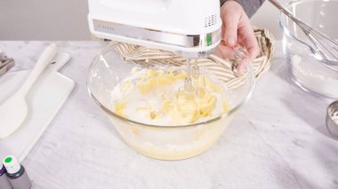 Adım adım. Vanilyalı Mardi Gras kekleri pişirmek için karışımı elektrikli mikserle karıştırıyorum..