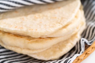 Mutfak havlusuna sarılı taze pişmiş ekmek yığını..