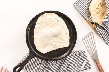 Düz yatıyordu. Dökme demir tavada ev yapımı ekmek hazırlıyorum..