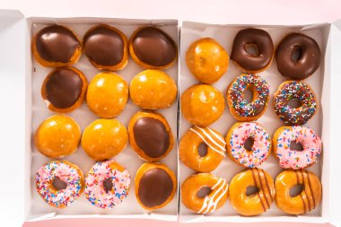 Düz yatıyordu. Beyaz bir karton kutuda mağazadan alınmış donutların çeşitliliği.