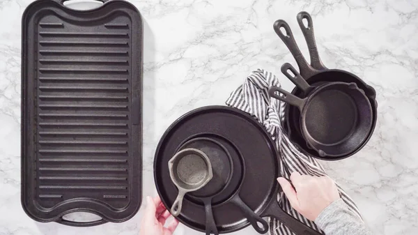 Düz yatıyordu. Mermer tezgahtaki dökme demir mutfak malzemelerinin çeşitliliği.