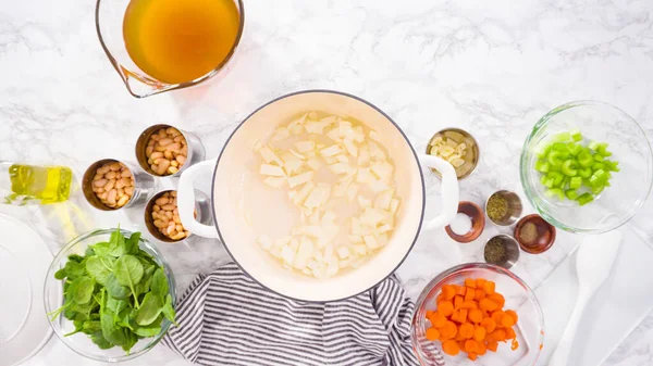 Dökme demir Hollanda fırınında vejetaryen beyaz fasulye çorbası pişirmek.