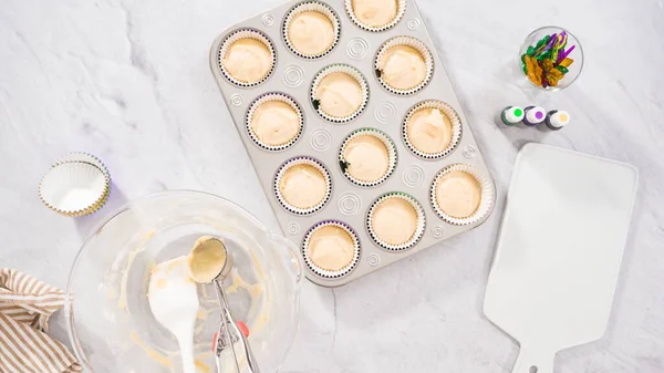 Düz yatıyordu. Adım adım. Vanilyalı Mardi Gras keki pişirmek için kek hamurunu folyoya batırıyorum..