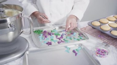 Düz yatıyordu. Adım adım. Vanilyalı kekleri süslemek için silikon kalıplı çikolata denizkızı kuyruğu yapıyorum..