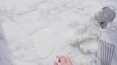Düz yatıyordu. Adım adım. Beyaz fondantımızı mermer tezgahta yuvarlıyoruz..