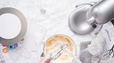 Tereyağlı krema yapmak için mutfak mikserinin malzemelerini karıştırıyorum..