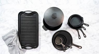 Düz yatıyordu. Mermer zemin üzerinde dökme demir tavaların çeşitliliği.