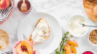 Düz yatıyordu. Adım adım. Ciabatta ekmeğinde ricotta ve şeftalili tost yapmak için organik şeftali dilimliyorum..