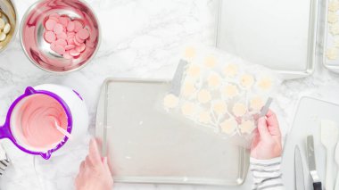 Düz yatıyordu. Adım adım. Çikolatalı kar tanelerini plastik çikolata kalıbından kurabiye tepsisine atmak..