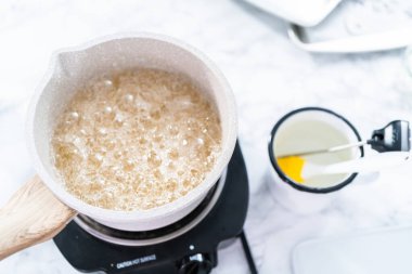 Ev yapımı lolipop yapmak için tencerede karamelize şeker.