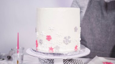 Adım adım. Yuvarlak funfetti pastasını pembe ve beyaz fondant kar taneleriyle süslüyorum..