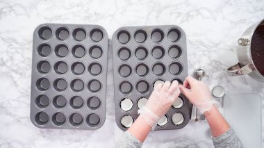 Düz yatıyordu. Adım adım. Mini çikolatalı kek pişirmek için kek kalıplarıyla kek tepsisi hazırlıyorum..