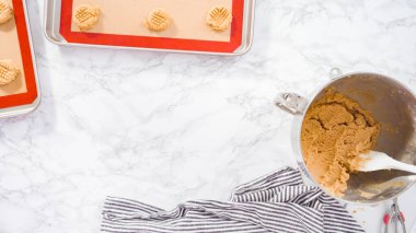 Düz yatıyordu. Adım adım. Fıstık ezmeli kurabiye hamurunu hamur kepçesiyle fırçalamak..