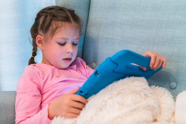 小女孩在家里读平板电脑上的书 — 图库照片