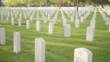 Denver, Colorado, ABD-26 Mayıs 2019 - Anma Günü 'nde Fort Logan Ulusal Mezarlığı' nda beyaz mermer mezar taşlarının yanında küçük Amerikan Bayrakları.