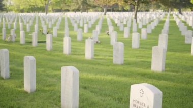 Denver, Colorado, ABD-26 Mayıs 2019 - Anma Günü 'nde Fort Logan Ulusal Mezarlığı' nda beyaz mermer mezar taşlarının yanında küçük Amerikan Bayrakları.