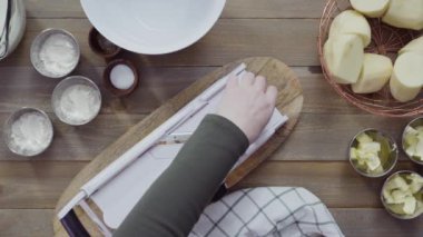 Düz yatıyordu. V-Blade mandolininde organik altın patatesleri dilimlemek..