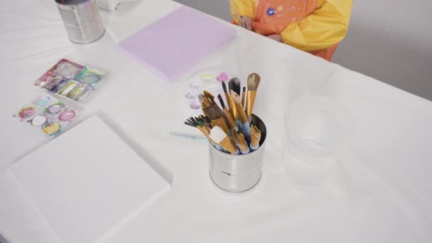 小女孩和妈妈一起在帆布上画丙烯酸颜料 准备做一个远距离学习的艺术项目 — 图库视频影像
