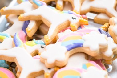 Tek boynuzlu at şeker çerezleri mavi bir arka plan üzerinde kraliyet krema ve gıda glitter ile dekore.