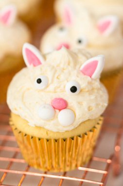 Paskalya için beyaz bir buttercream buzlanma ve tavşan kulakları ile vanilya cupcakes dekorasyon.