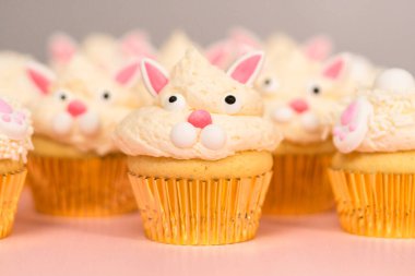 Pembe arka planda Paskalya tavşanı kekleri.