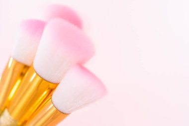 Pembe arka planda tek boynuzlu at renk makyaj fırçaları.