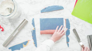 Adım adım. Düz yatıyordu. Kırmızı, beyaz ve mavi fırıldak şekerli kurabiyeler pişirmek için hamuru yuvarlıyor..