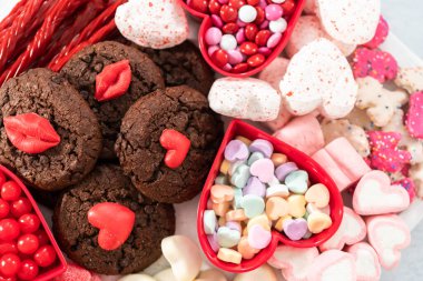 Çeşitli kurabiye ve şekerlemelerle Sevgililer Günü peynir tahtası.