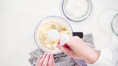 Düz yatıyordu. Ev yapımı hindistan cevizi kurabiyeleri hazırlamak için gıda işlemcisinde malzemeler karıştırılıyor..