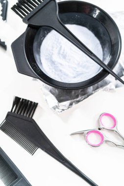 Siyah plastik bir kasede beyaz arka planda saç boyası tozu..