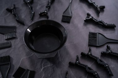 Siyah saç rengi boya seti ve siyah arka planda karıştırma kabı..